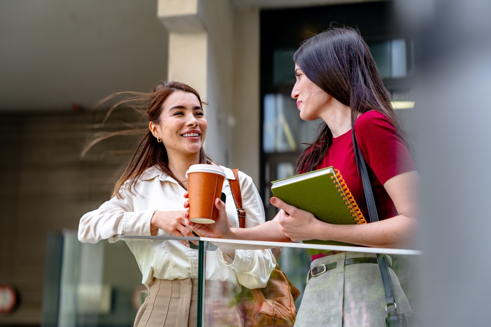 Two women talking and smiling at work
